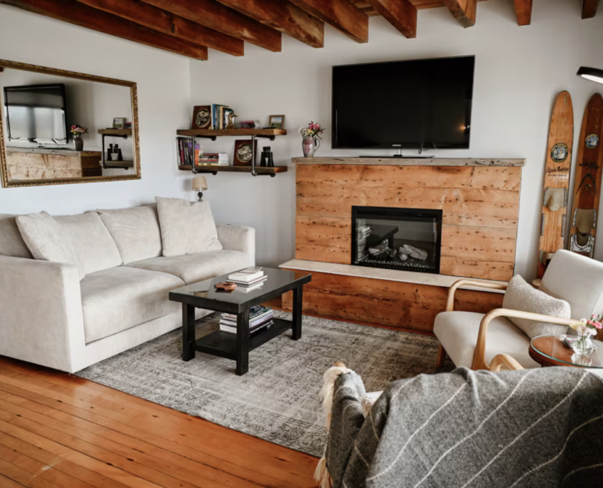 living room with fireplace, tv and wood beams